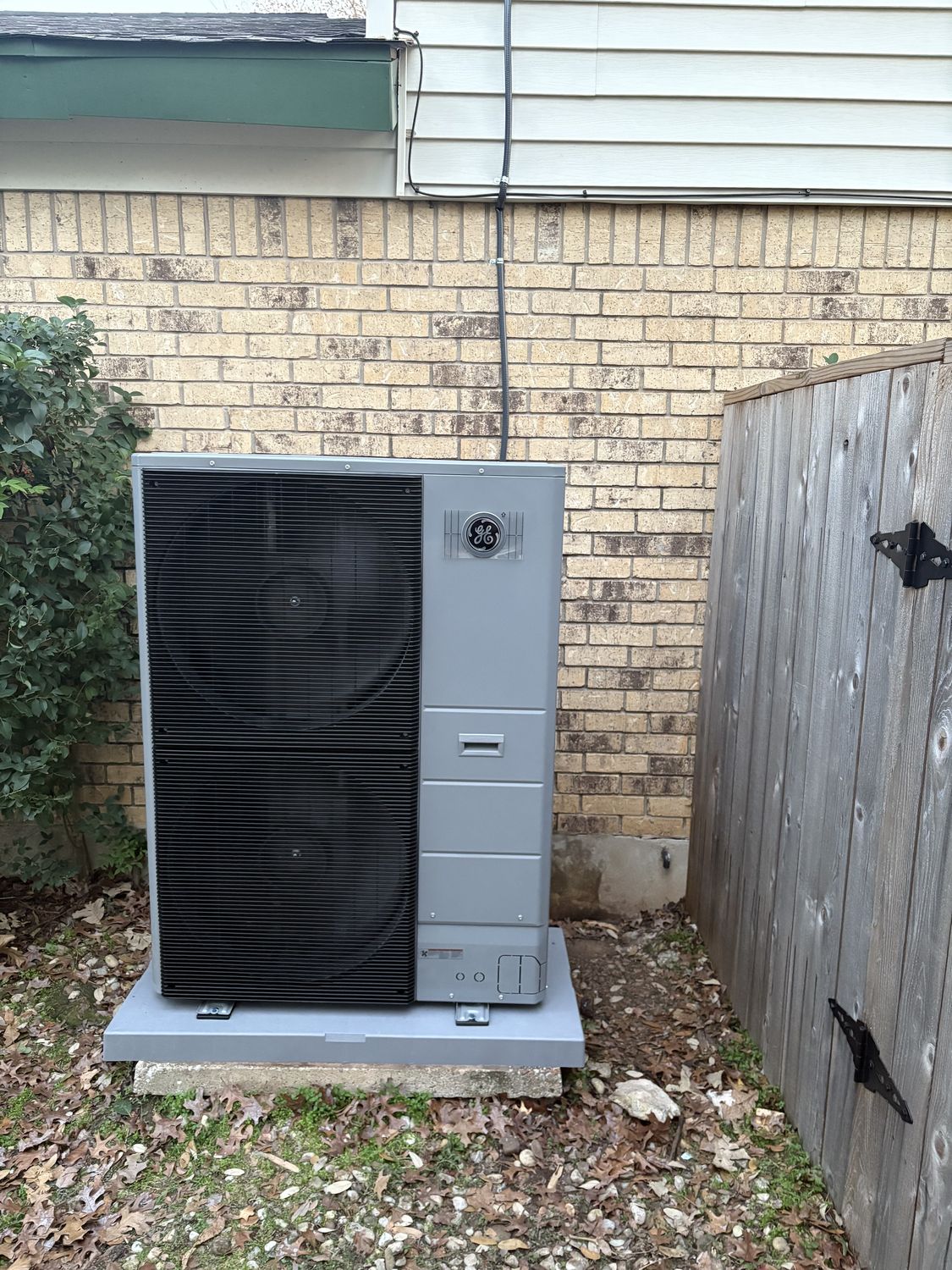 An outdoor AC condenser unit installed beside an Austin home